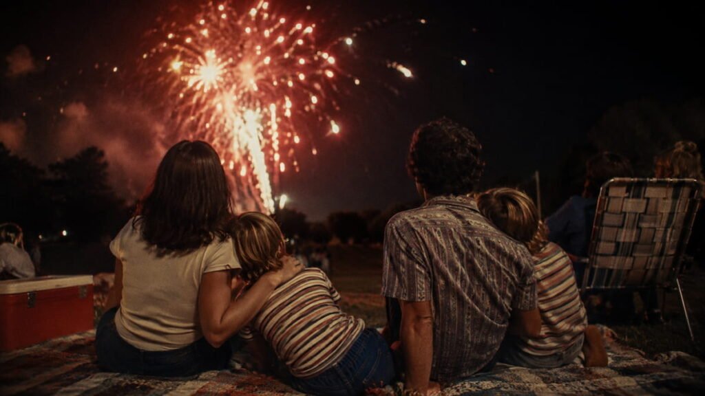 Vintage 1970s family watching Fourth of July fireworks from a lawn